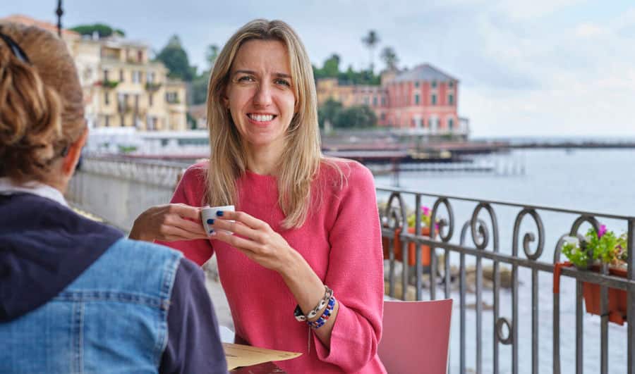 Photo d'Elise assise dans un café. Elle utilise Luja femme pour gérer ses symptômes vésicaux liés à sa SEP. 