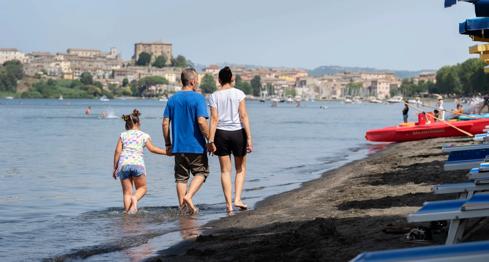 Photo d'Andrea marchant sur la plage avec sa famille. Andrea est atteint de sclérose en plaques et utilise le TAI pour gérer ses problèmes intestinaux. 