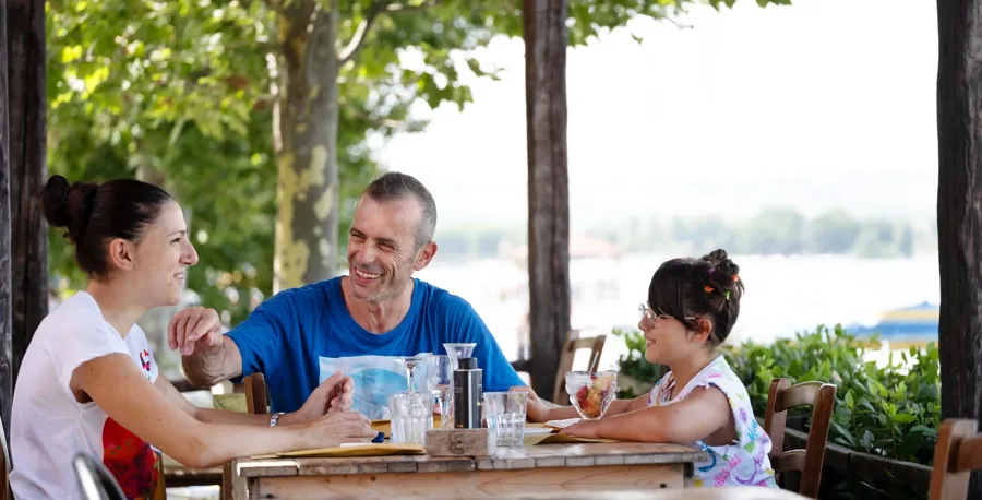 Andrea est assis à une table de restaurant avec sa famille. Si vous avez des questions ou des préoccupations concernant votre vessie et vos intestins lorsque vous vivez avec la SEP, contactez Coloplast Care pour obtenir de l'aide.