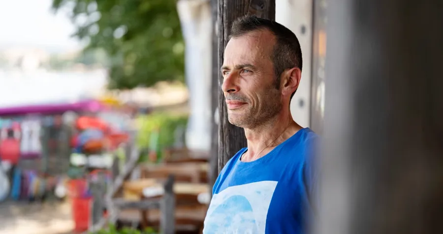 Photo portrait d'Andrea à l'extérieur. Le cathétérisme intermittent nécessite un processus d'apprentissage. Au fil du temps, Andrea a appris à se cathétériser lors de ses déplacements et a développé sa propre routine personnalisée, adaptée à ses besoins.