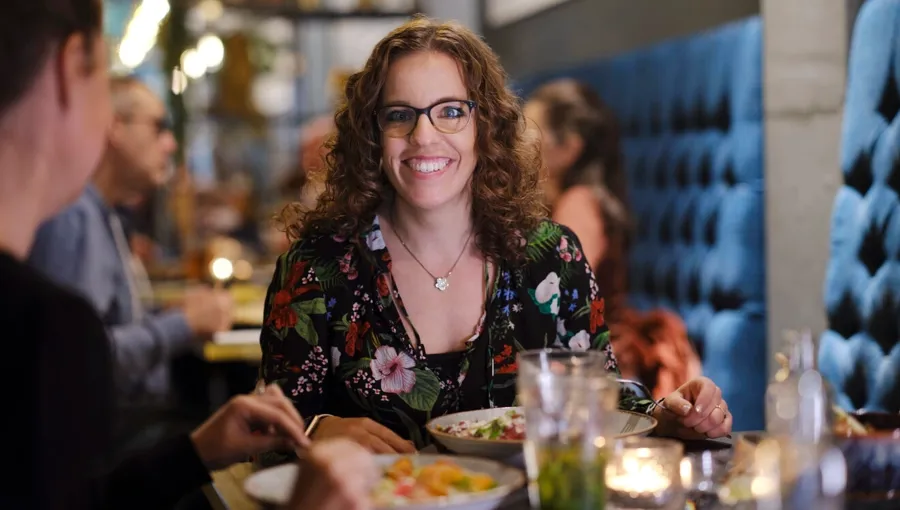 Photo de Marianne en train de dîner avec des amis. Marianne bénéficie d'un solide réseau d'amis qui l'aident. 